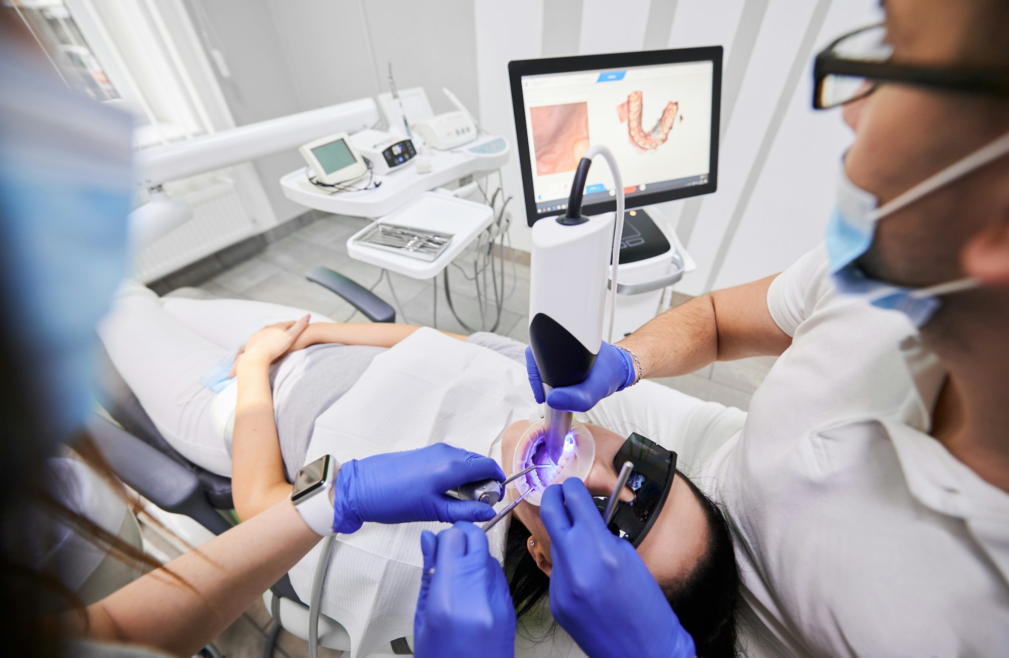 Doctor scanning patient mouth with modern intraoral scanner.